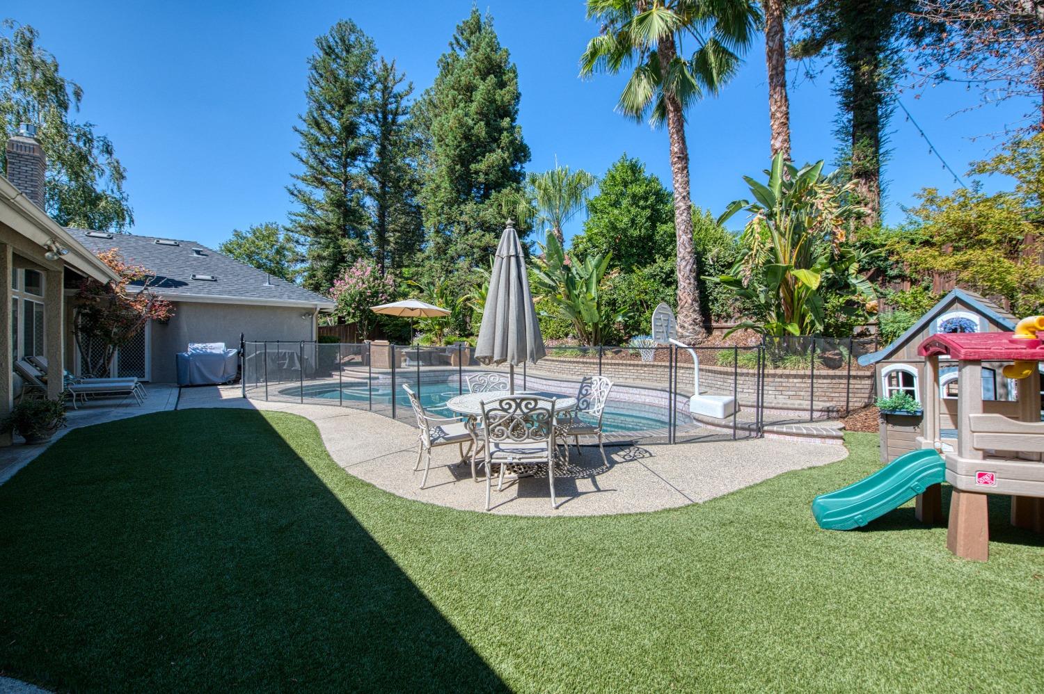692 East Blue Ridge Road Fresno, CA 93725 - Photo 56 of 68 a view of a backyard with table and chairs potted plants and palm tree