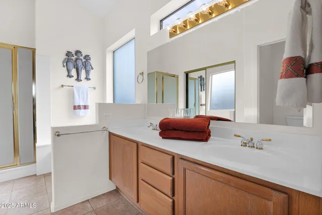 a front view of a building with glass windows and plants