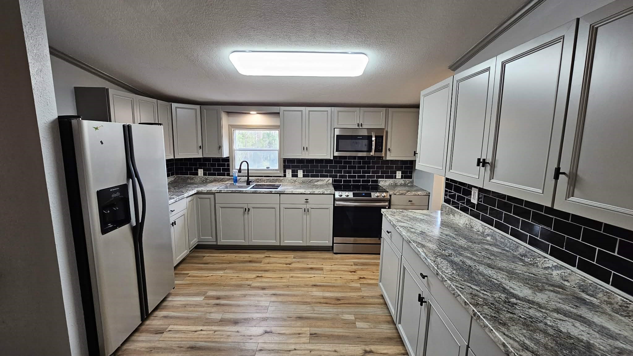 28183 Ramble Lane Hilliard, FL 32046 - Photo 5 of 34 a kitchen with stainless steel appliances a refrigerator sink and cabinets