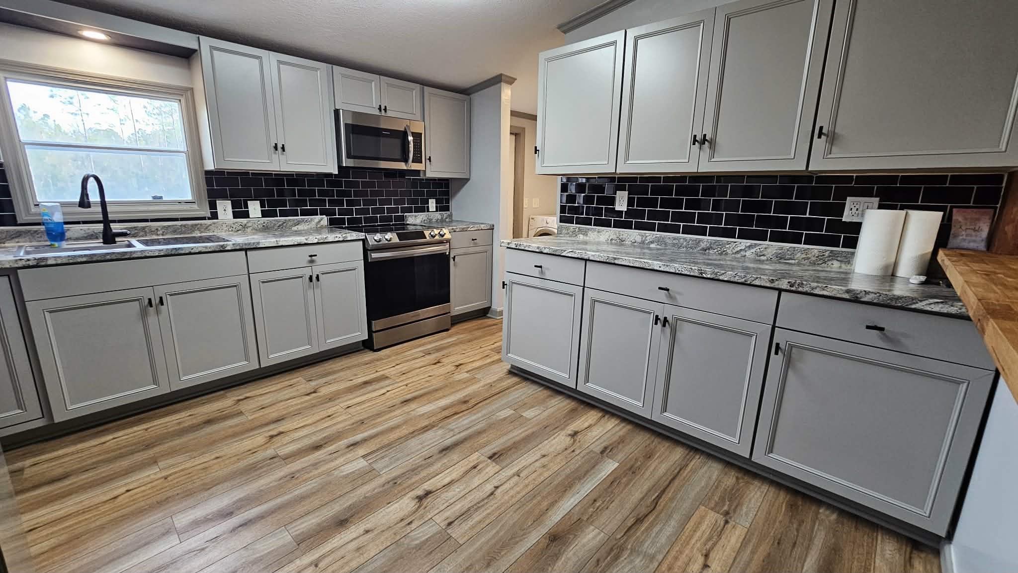28183 Ramble Lane Hilliard, FL 32046 - Photo 7 of 34 a kitchen with stainless steel appliances granite countertop a stove a sink and white cabinets