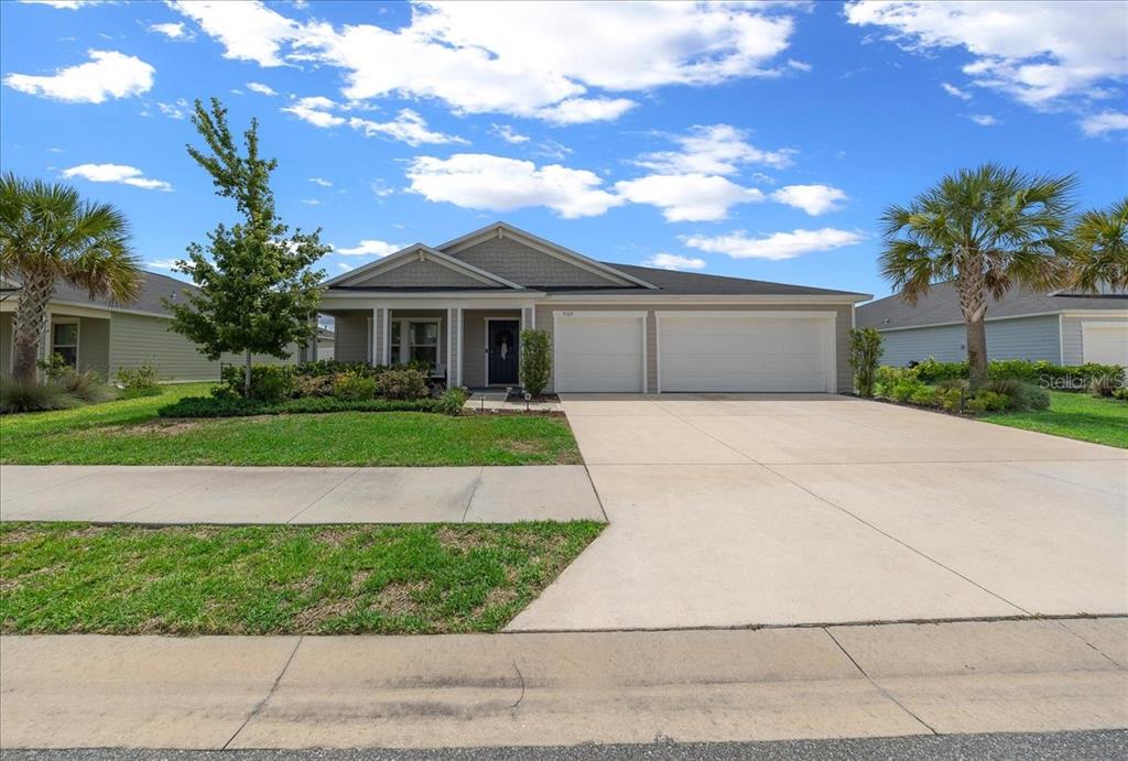 9329 Southwest 57th Terrace Ocala, FL 34476 - Photo 43 of 64 a front view of a house with a yard and potted plants