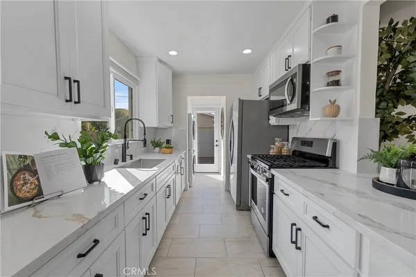 a large kitchen with stainless steel appliances lots of counter space sink and cabinets