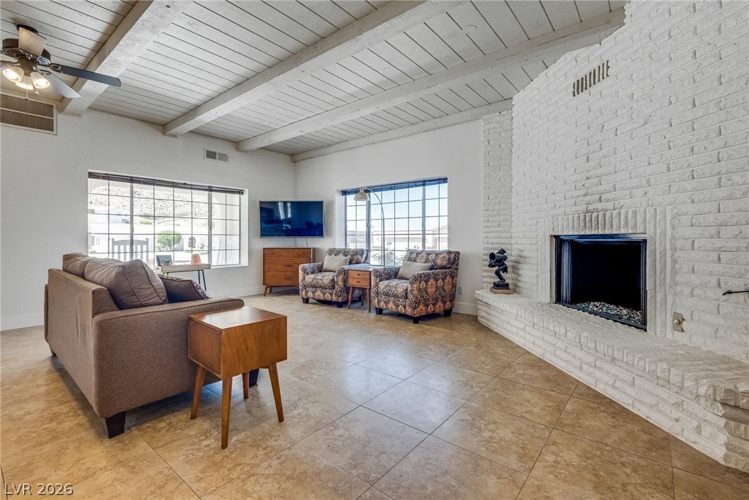 524 Swallow Cove Boulder City, NV 89005 - Photo 10 of 58 A striking white brick fireplace anchors this spacious living area with vaulted ceilings and ample natural illumination.