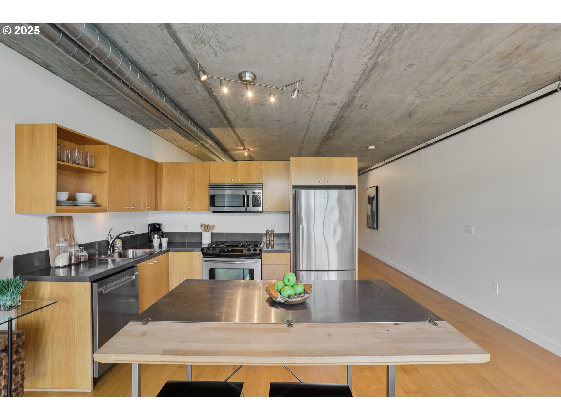 1926 West Burnside Street, Unit 912 Portland, OR 97209 - Photo 9 of 19 a kitchen with stainless steel appliances a stove a refrigerator a sink a counter top space and cabinets