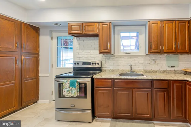 a kitchen with stainless steel appliances granite countertop a sink and a refrigerator