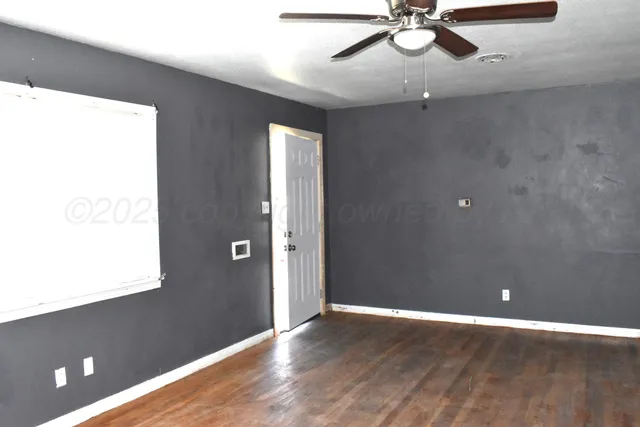 a view of a livingroom with a ceiling fan and window