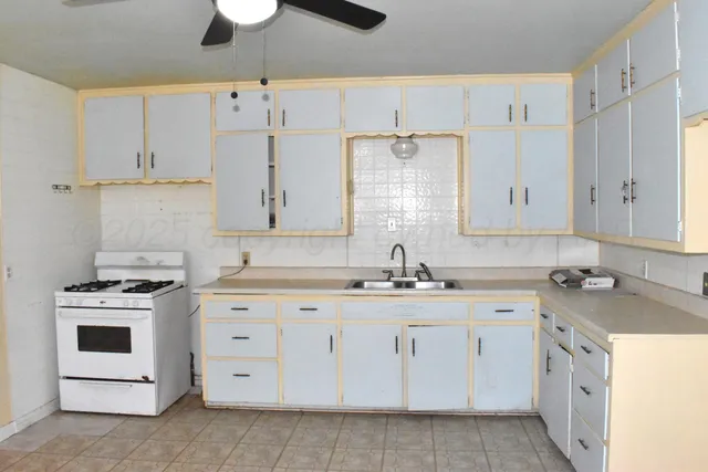 a kitchen with cabinets appliances a sink and a stove