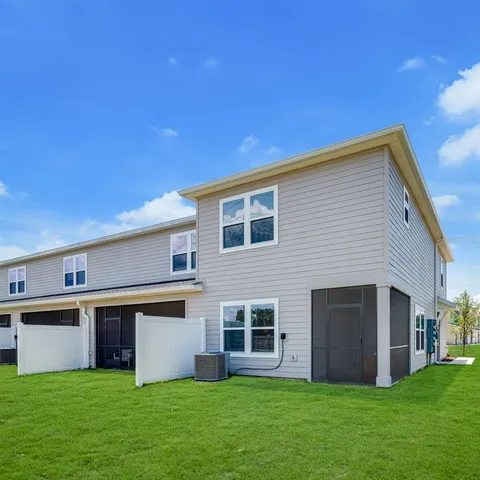 a view of a house with a yard and a large tree