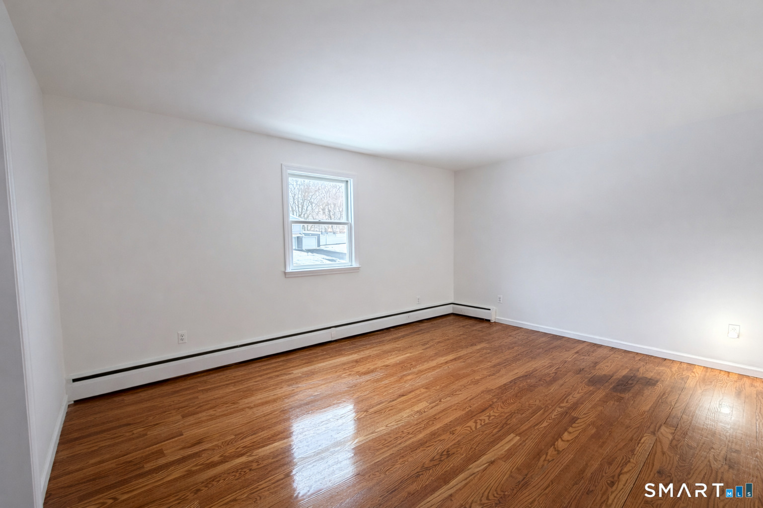 15 Dairy Farm Road Norwalk, CT 06851 - Photo 3 of 9 an empty room with wooden floor and windows