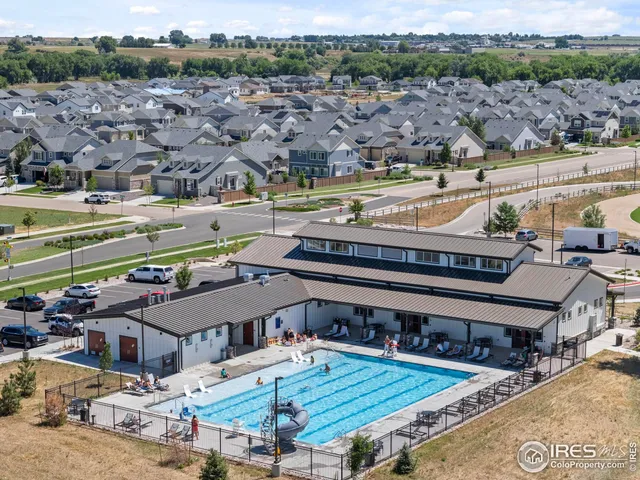 an aerial view of a swimming pool with outdoor seating