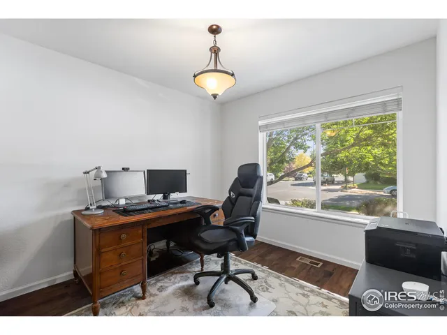 a view of a workspace with furniture and a window