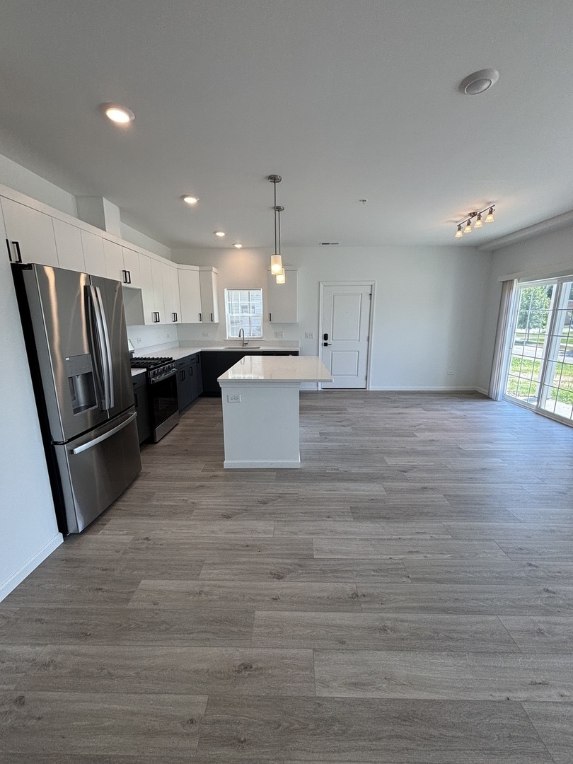 30 South 14th Street, Unit E St. Charles, IL 60174 - Photo 2 of 10 a large kitchen with a refrigerator a stove a microwave and white cabinets