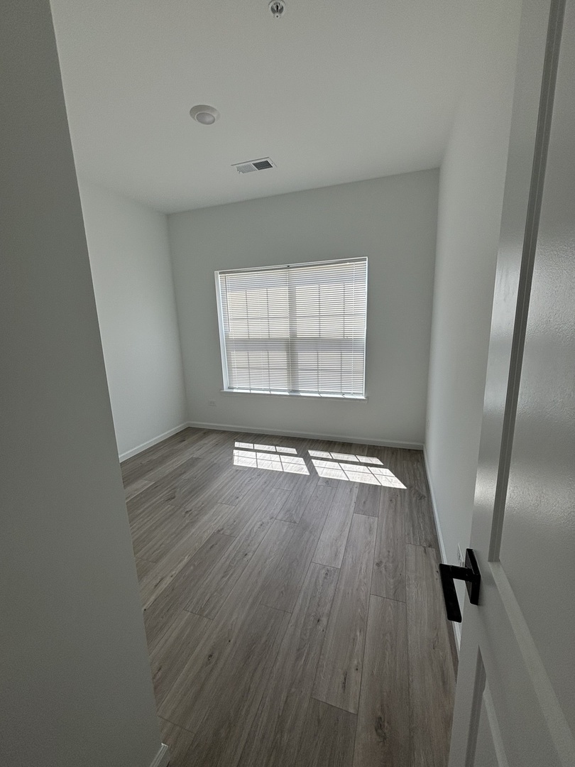 30 South 14th Street, Unit E St. Charles, IL 60174 - Photo 6 of 10 an empty room with wooden floor and windows