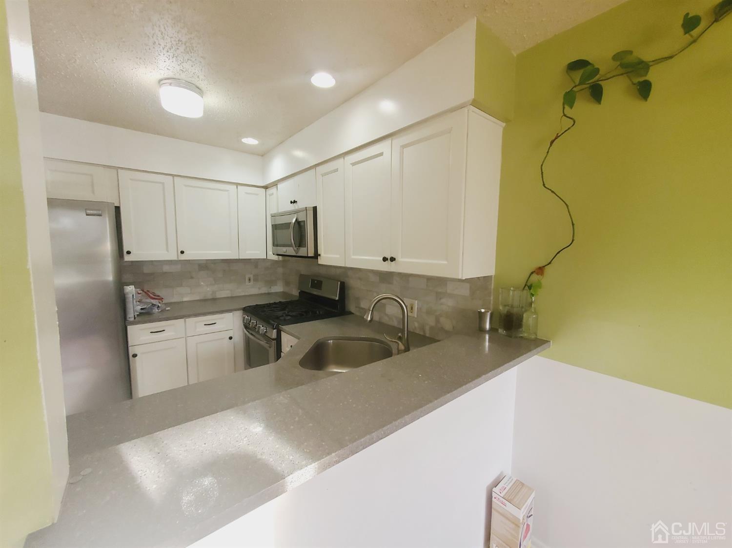 148 Nebula Road Piscataway, NJ 08854 - Photo 5 of 22 a kitchen with a sink a refrigerator and cabinets