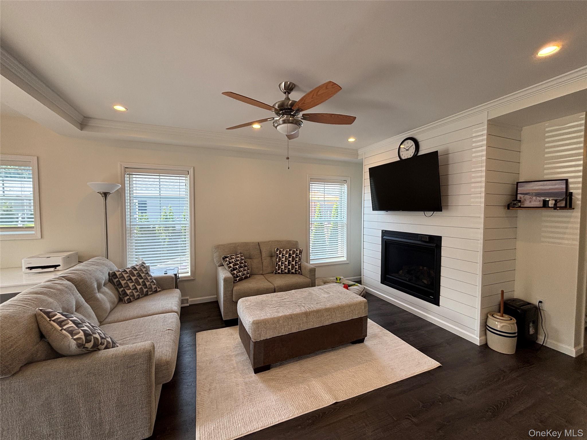 1661 Old Country Road, Unit 563 Riverhead, NY 11901 - Photo 11 of 43 a living room with furniture a fireplace and a flat screen tv