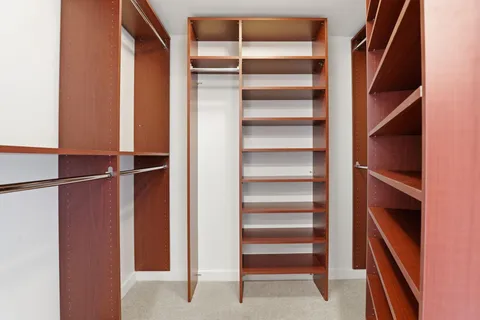 a view of walk in closet with empty racks