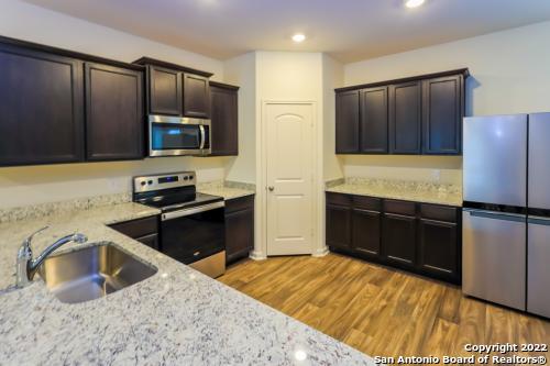 a kitchen with granite countertop a refrigerator and a sink