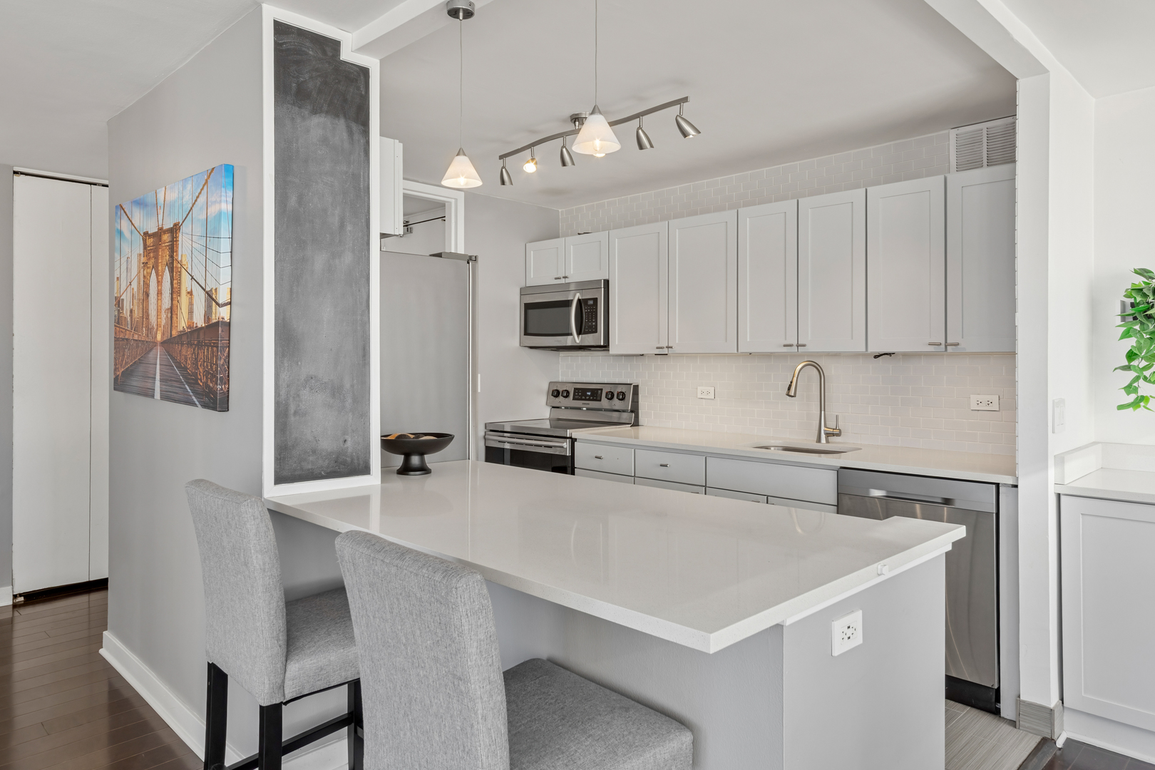 655 West Irving Park Road, Unit 1301 Chicago, IL 60613 - Photo 5 of 22 a kitchen with a sink a stove a refrigerator and white cabinets