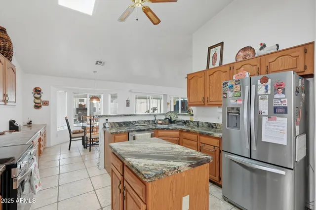 a kitchen with stainless steel appliances granite countertop a refrigerator and a stove