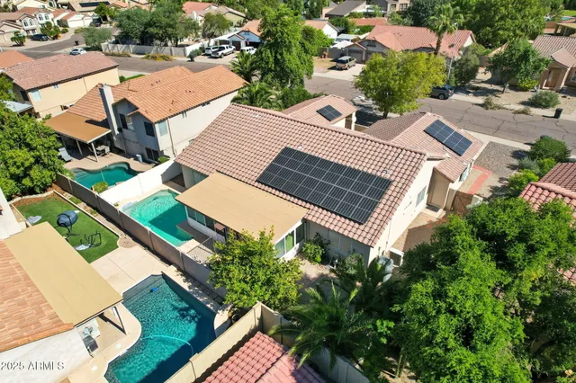 an aerial view of a house with outdoor space and trees all around