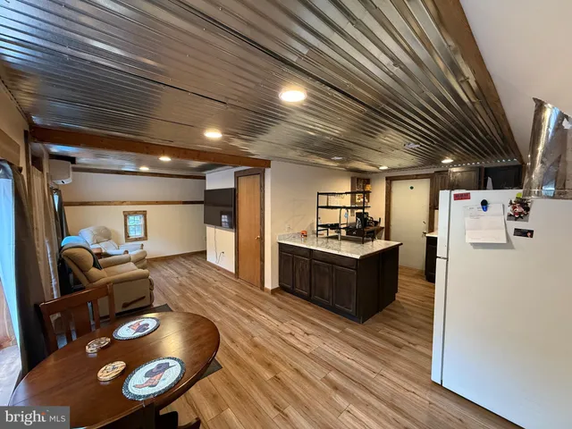 a kitchen with stainless steel appliances granite countertop a sink a stove and a wooden floor