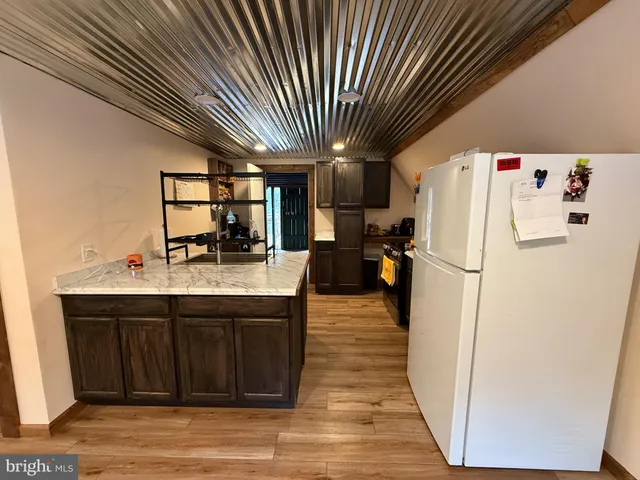 a kitchen with wooden cabinets sink and stove
