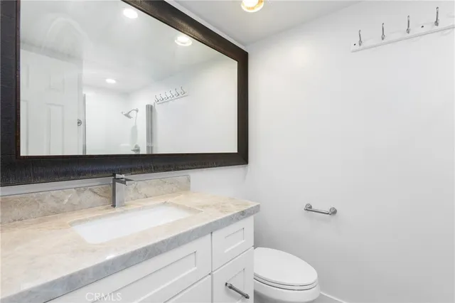 a bathroom with a sink a toilet and mirror