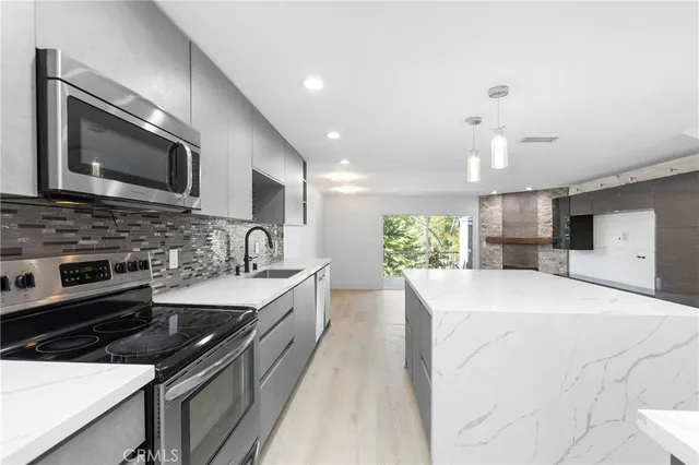 a large kitchen with stainless steel appliances kitchen island a stove and a sink