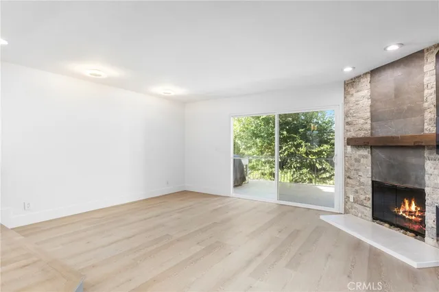 a view of an empty room with a fireplace and a window
