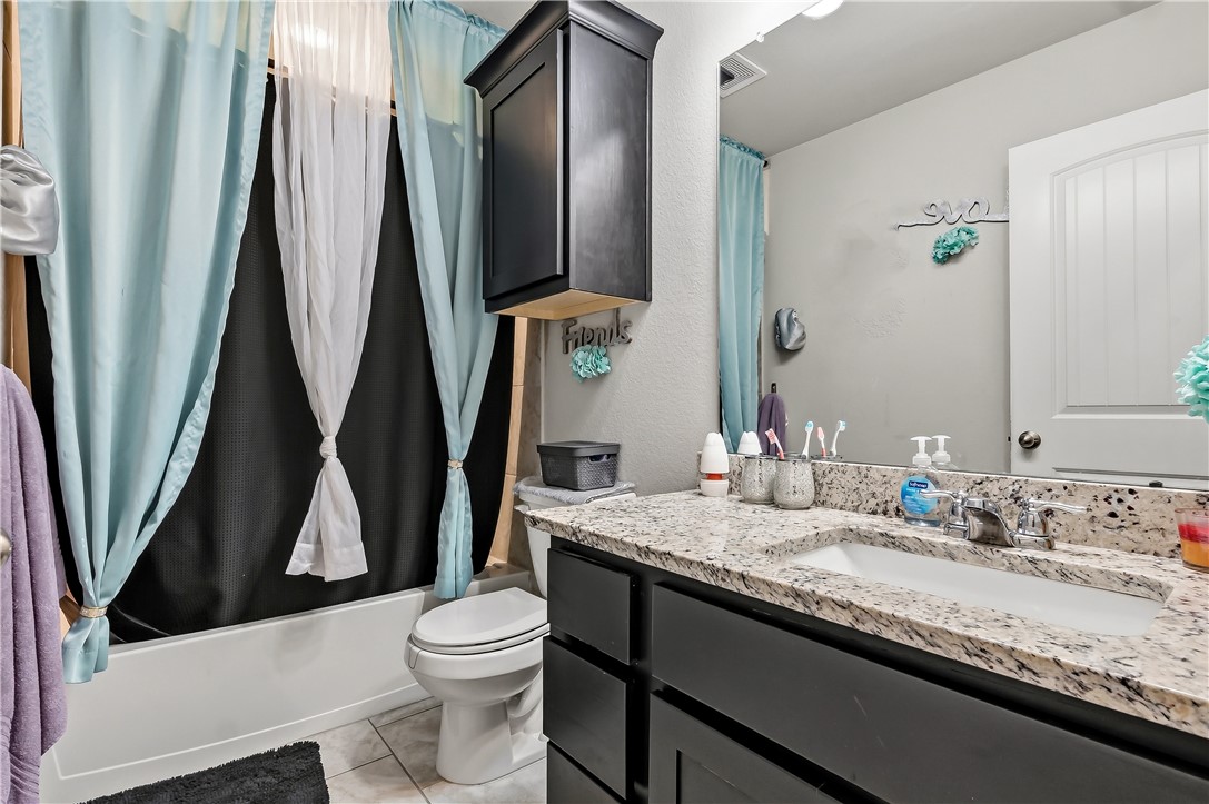 2009 Chief Street Bryan, TX 77807 - Photo 20 of 27 a bathroom with a granite countertop sink toilet and a mirror