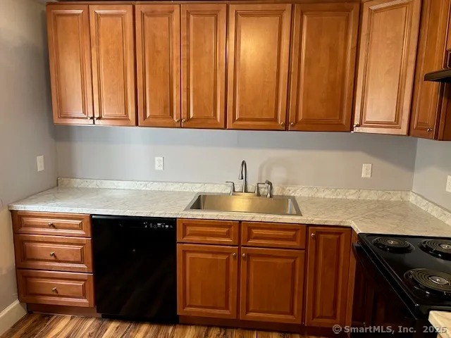 a kitchen with granite countertop cabinets and black appliances
