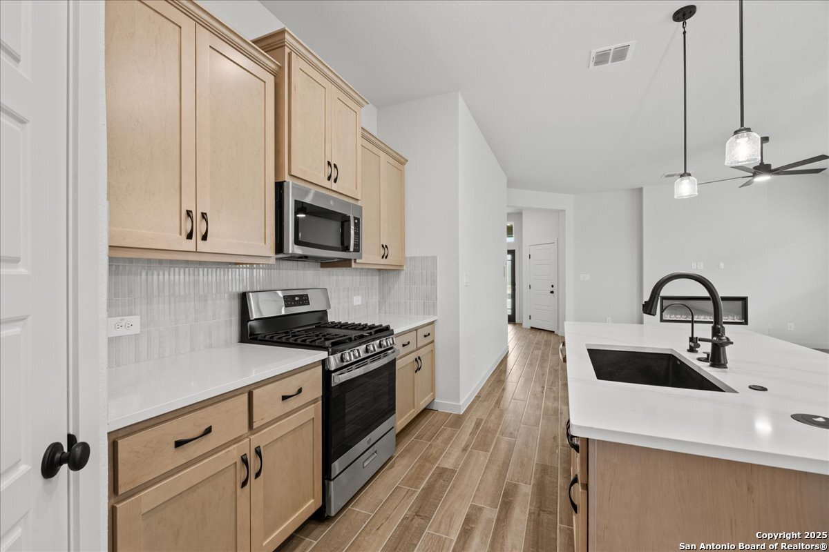 2009 Shepards Street Seguin, TX 78155 - Photo 6 of 22 a kitchen with stainless steel appliances granite countertop a sink a stove and a refrigerator