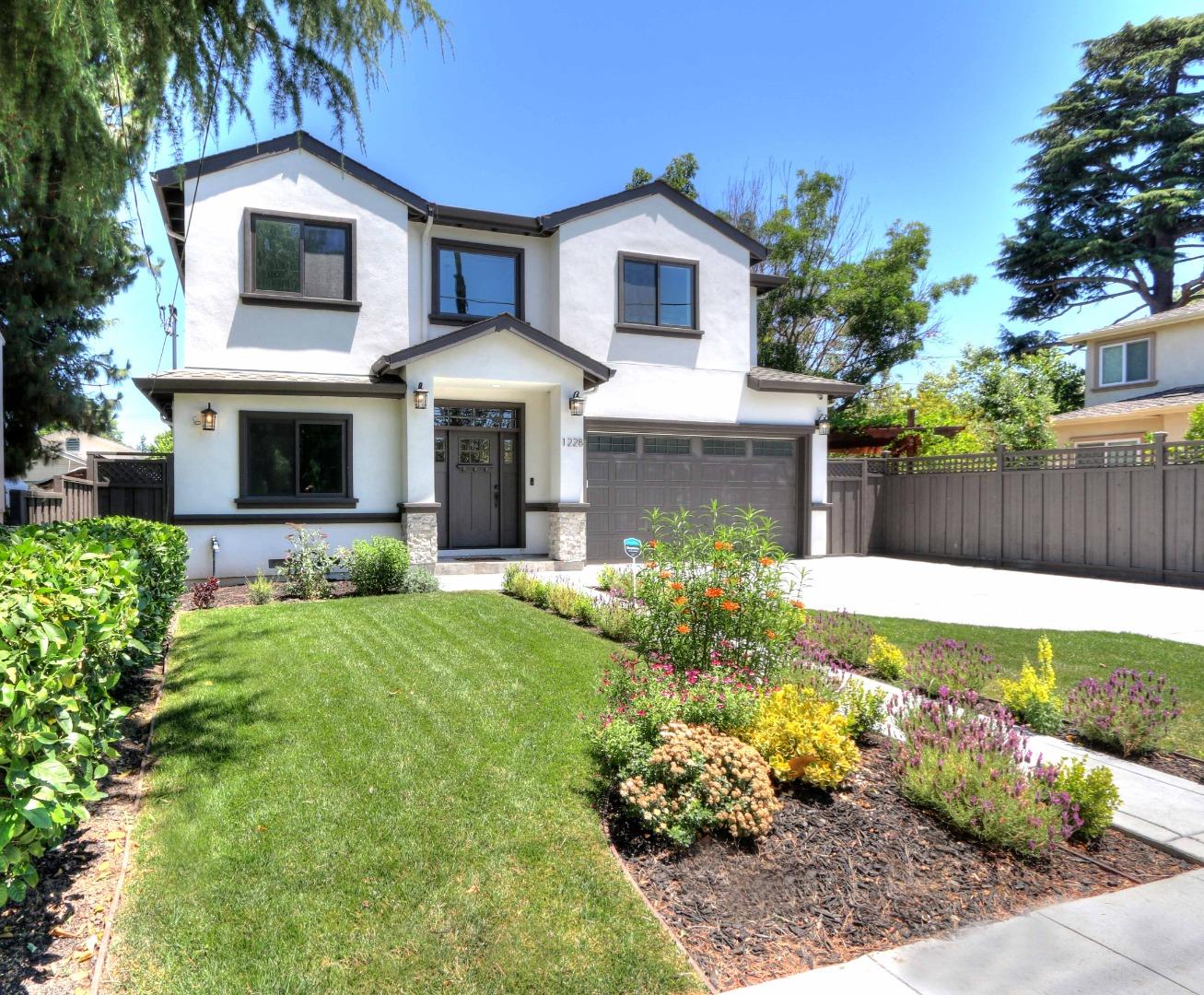 a front view of a house with a yard and a garden