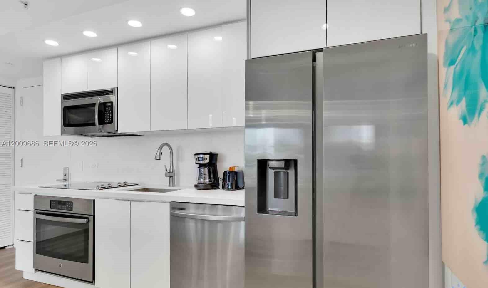 2602 East Hallandale Beach Boulevard, Unit R506 Hallandale Beach, FL 33009 - Photo 4 of 10 a kitchen with stainless steel appliances a refrigerator sink and microwave