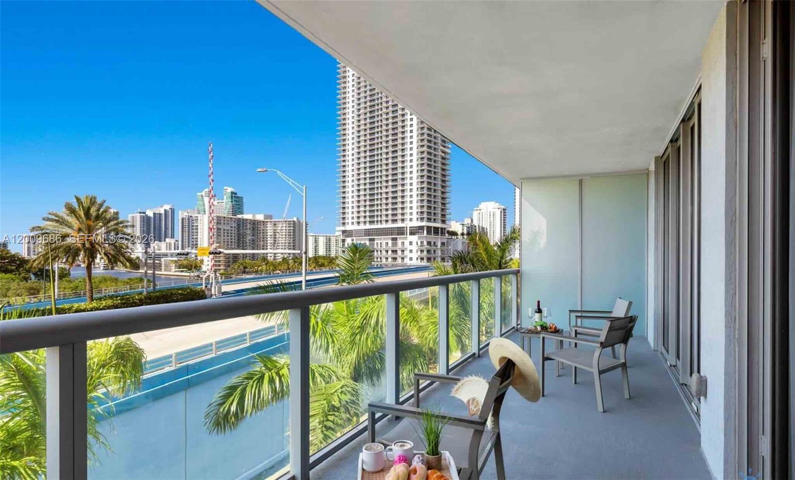 2602 East Hallandale Beach Boulevard, Unit R506 Hallandale Beach, FL 33009 - Photo 6 of 10 a view of a city from a balcony with furniture