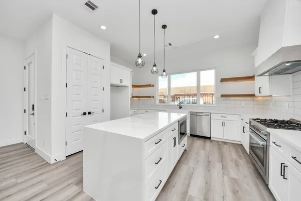 a kitchen with white cabinets and white appliances