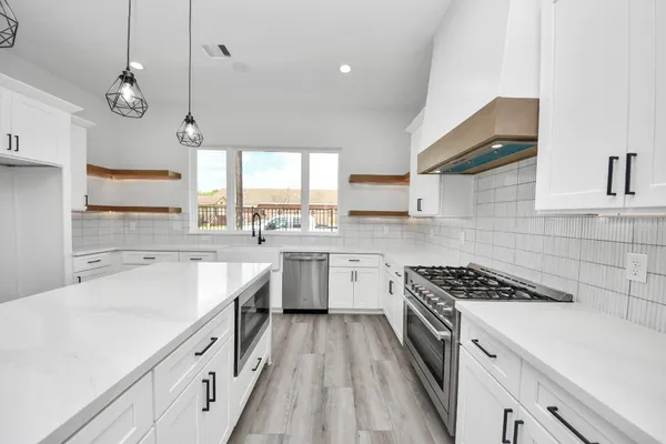 a kitchen with a sink stove cabinets and window