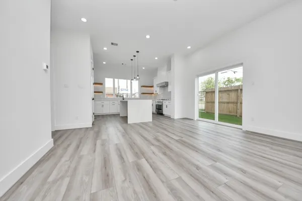 a view of empty room with wooden floor and windows