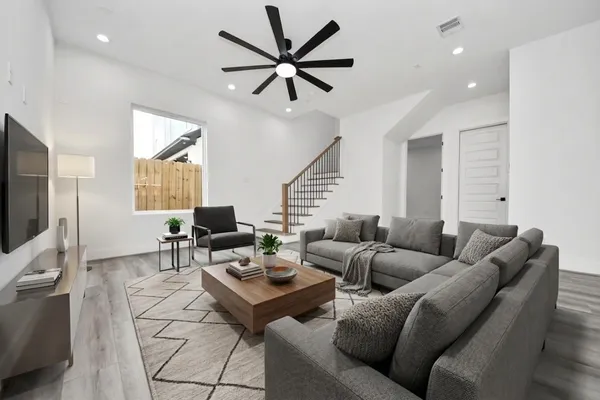 a living room with furniture a ceiling fan and a rug