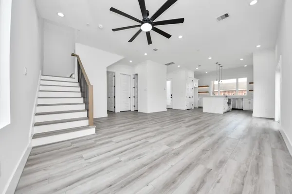 a view of a room with wooden floor and a ceiling fan