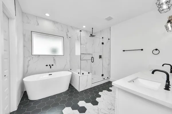 a bathroom with a white tub shower and sink