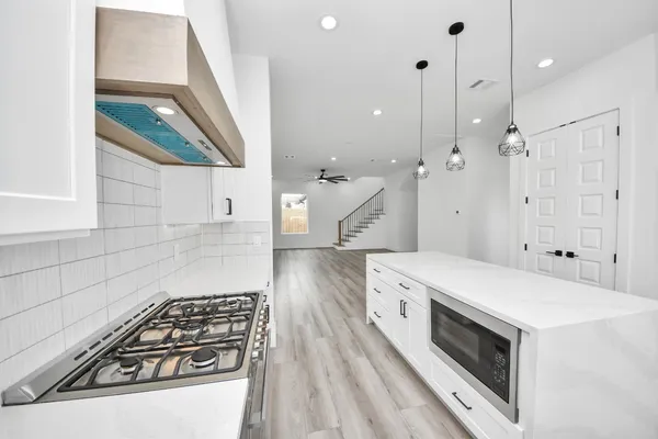 a kitchen with a stove and a wooden floor