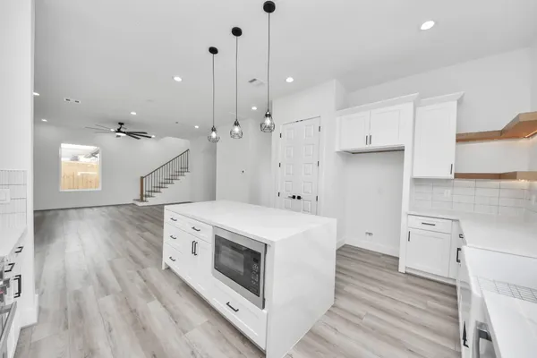 a view of a kitchen counter space a stove and wooden floor