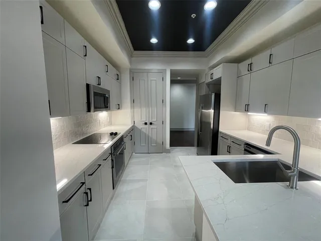 a kitchen with stainless steel appliances granite countertop a sink a stove and a refrigerator