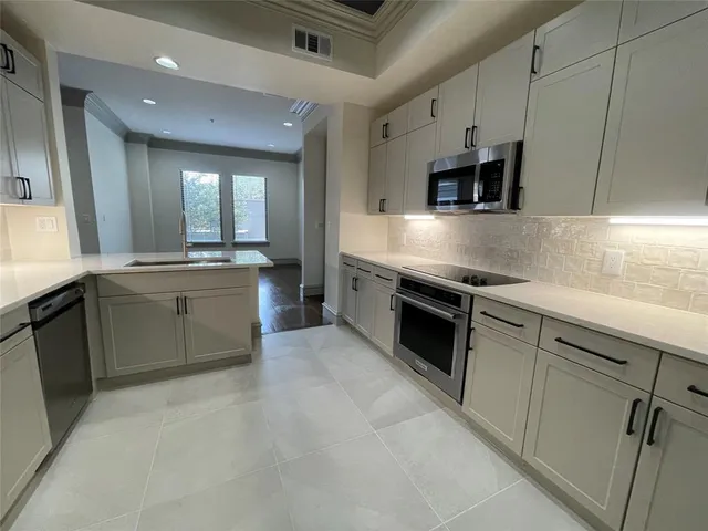 a kitchen with stainless steel appliances granite countertop a sink and a stove