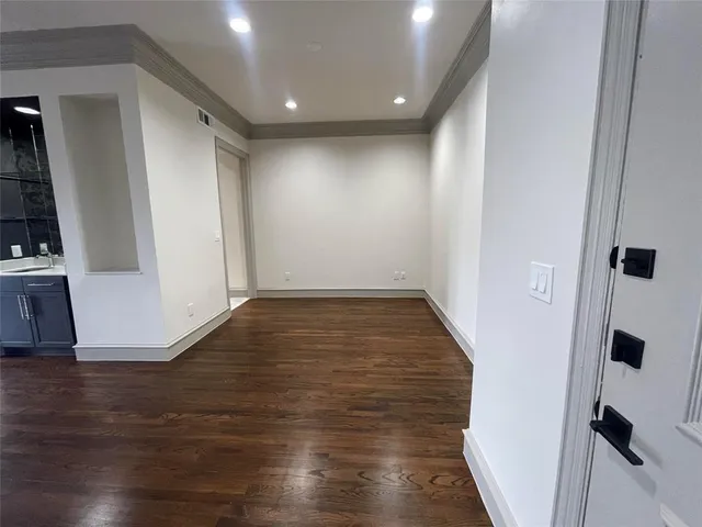 an empty room with wooden floor and entrance