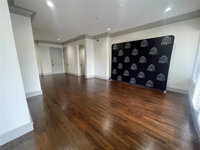 a view of an empty room with wooden floor and closet