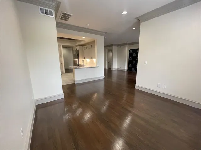 a view of a hallway with wooden floor and a living room