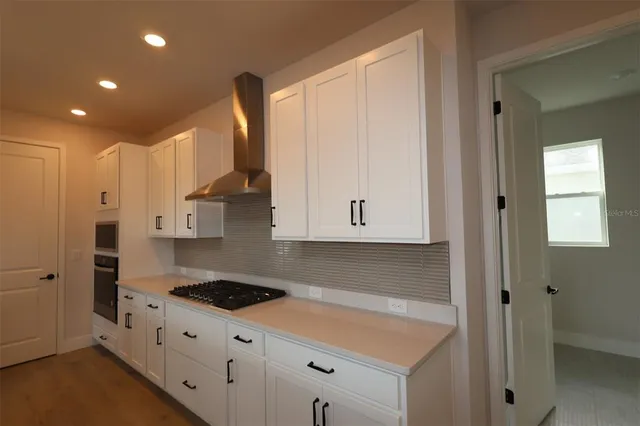 a kitchen with granite countertop white cabinets and black appliances