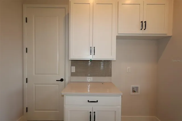 a view of a living room and kitchen with a sink cabinets